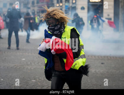 Paris, Frankreich. 8. Dez 2018. Einer Frau mit einem französischen Flagge mit dem Gesicht in der Nähe des Arc de Triomphe während der Protest gelbe Weste' in Paris gesehen. Ohne politische Zugehörigkeit, die 'Bewegung Kundgebungen gelbe Weste' in verschiedenen Städten in Frankreich in diesem Samstag gegen Steuern und steigende Kraftstoffpreise. Credit: SOPA Images Limited/Alamy leben Nachrichten Stockfoto