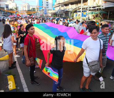 Quezon, Philippinen. 8. Dez 2018. Leute gesehen, die ihre riesigen Regenbogen Flagge als Symbol für Freiheit und Gleichheit während der Pride. Die Quezon City Regierung und der QC-Stolz Rat Host wieder die LGBT Pride. Es ist Ziel ist die Kampagne für HIV und AIDS-Prävention und der Menschenrechte. Credit: SOPA Images Limited/Alamy leben Nachrichten Stockfoto