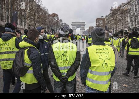 Paris, Frankreich. 8 Dez, 2018. Die Demonstranten mit schriftlicher anti Längestrich und Regierung Parolen vor der Arc De Triomphe in Paris. Vierte Wochenende im Gelben Westen anti Proteste in Paris, mit Tausenden von Demonstranten vandalizing Autos, Geschäfte oder öffentliche Eigenschaft, Einrichten von Straßensperren um Champs Elysees und Arc De Triomphe. Polizei verwendet, Tränengas und über tausend Verhaftungen. Credit: Georgios Papadopoulos/SOPA Images/ZUMA Draht/Alamy leben Nachrichten Stockfoto