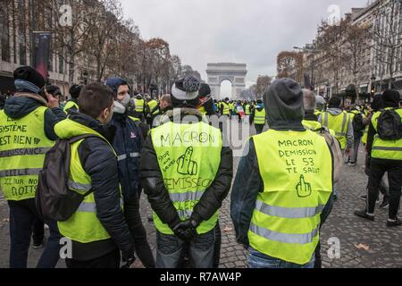 Paris, Frankreich. 8. Dez 2018. Die Demonstranten mit schriftlicher anti Längestrich und Regierung Parolen vor der Arc De Triomphe in Paris. Vierte Wochenende im Gelben Westen anti Proteste in Paris, mit Tausenden von Demonstranten vandalizing Autos, Geschäfte oder öffentliche Eigenschaft, Einrichten von Straßensperren um Champs Elysees und Arc De Triomphe. Polizei verwendet, Tränengas und über tausend Verhaftungen. Credit: SOPA Images Limited/Alamy leben Nachrichten Stockfoto