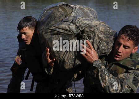 U.S. Army Rangers 1. Lt. Ian Concannon und 1 Leutnant Scott Rapuano, in die 3.Infanterie Division, tragen ihre ruck Säcke von Sieg Teich während der Bekämpfung Wasser überleben Teil der besten Ranger Wettbewerb 2017 in Fort Benning, Ga., 9. April 2017. Die 34. jährliche David E. Grange jr. Am besten Ranger Wettbewerb 2017 ist eine dreitägige Veranstaltung, bestehend aus Herausforderungen Konkurrenten körperlichen, geistigen und technischen Fähigkeiten. Stockfoto