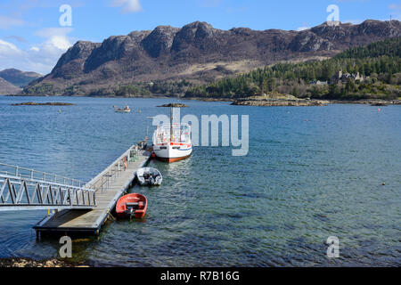 Touristische Yacht "Sula Mhor" gebunden an der Anlegestelle am Loch Carron mit weit entfernten Felsen im Hintergrund - plockton Dorf, Hochland, Schottland Stockfoto