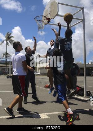 KAILUA, Hawaii - Marines mit Hauptsitz Bataillon, Marine Corps Base Hawaii, Basketball spielen mit Studierenden an Kailua Mittelschule, 12. April 2017. Marines gab zurück zu ihrer Gemeinschaft durch Freiwilligenarbeit an KIS für die Schule" Mittwoch Volunteer Programm." Das Programm bietet Marines die Möglichkeit, mit den Studierenden zu interagieren, unterstützen die Lehrer im Klassenzimmer, und positive Vorbilder für die Kinder. Stockfoto