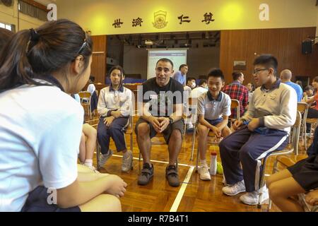 Hongkong (April 10, 2017) ein US-Marine Sailor mit USS Makin Island (LL 8), spricht mit den Kindern von Yan Chai Krankenhaus Gesetz Chan Chor Si Grundschule über seinen Job in der Marine während eines Community Relations Veranstaltung in Hong Kong, April 10. Die Marinesoldaten und Matrosen mit USS Makin Island und 11 Marine Expeditionary Unit (MEU) hatten die Möglichkeit, sich zu engagieren und Geschichten über ihre Erfahrungen auf dem Schiff und im Team building Sport und Spielen teilnehmen. Hong Kong ist eine von vielen Zwischenstationen der 11 MEU während ihrer westlichen Pazifik 16-2 Bereitstellung besucht. Stockfoto
