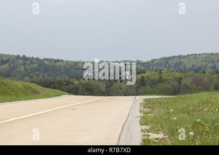 Ein UH-60 Black Hawk Hubschrauber und eine bulgarische Eurocopter AS 532 AL Cougar der bulgarischen Armee landen auf einem Flugplatz während der Durchführung einer simulierten medizinischen Evakuierung während Saber Junction 17 im Hohenfels Trainingsbereich, Deutschland, 8. Mai 2017. Säbel Junction 17 ist der US-Army Europe 2d Kavallerie-Regiment Kampftraining Zentrum Zertifizierung Übung, statt an den Joint Multinational Readiness Center in Hohenfels, Deutschland, April 25-Mai 19, 2017. Die Übung soll die Bereitschaft des Regiments, einheitliches Land tätig, mit Schwerpunkt auf Proben Stockfoto