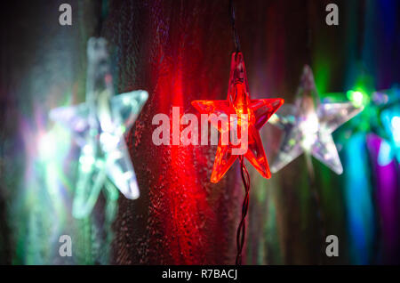 Farbenfroher, festlicher sternförmigen Weihnachtsbeleuchtung, die im Dunkeln leuchten. Stockfoto