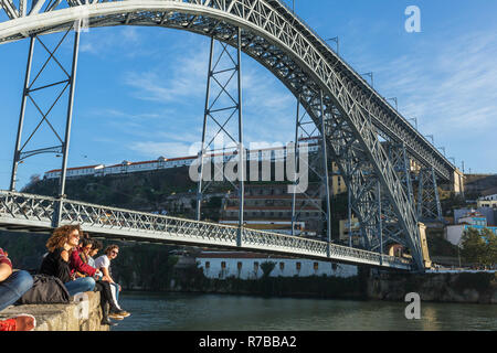 Porto, Portugal - Januar 19, 2018: Nicht identifizierte junge rucksacktouristen Rest unter die berühmte Brücke Ponte Dom Luis in Porto, Portugal Stockfoto