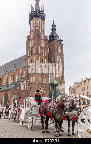 Krakau, Polen - 15. März 2018: Pferde Kutschen am Hauptplatz Rynek Glowny genannt in Krakau, Polen Stockfoto