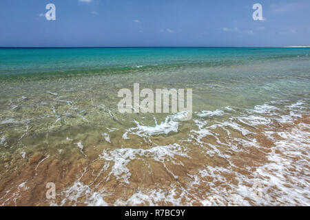 Kristallklares Wasser mit kleinen Wellen, azurblaues Meer im Hintergrund. Unberührte leer wilden Strand in Karpass Halbinsel, Nordzypern Stockfoto