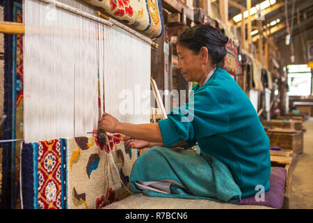 Darjeeling, Indien - 19. April 2017: Unbekannter tibetischen Frau arbeitet als Weaver in den Teppich Workshop des Tibetischen Flüchtling Self Help Center, Darjeeling, Stockfoto