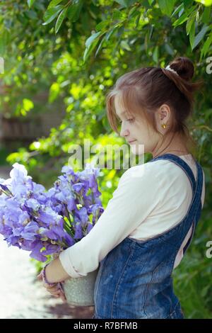 Mädchen, dass eine Schaufel im Garten mit Iris Stockfoto