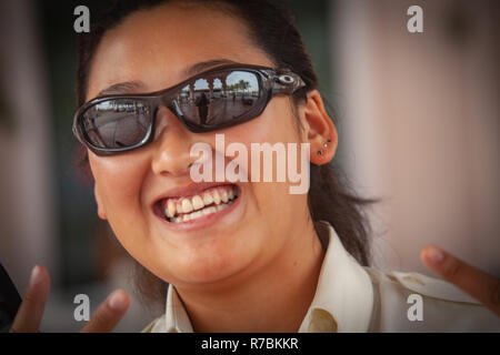 Glücklich lächelnde junge Dame mit Sonnenbrille arbeiten in Dubai, VAE Stockfoto