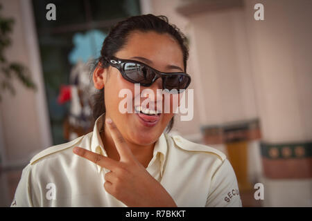 Glücklich lächelnde junge Dame mit Sonnenbrille arbeiten in Dubai, VAE Stockfoto