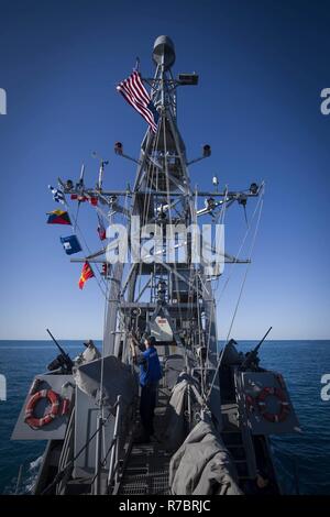 Karibik (08.Mai 2017) - der Betrieb Specialist Seaman Justen Gourley, zu den Cyclone zugeordnet - class Patrol coastal Schiff USS Zephyr (PC 8), wirft die Schiffe Flaggen während Meer und anker detail. Zephyr ist derzeit zur Unterstützung der Operation Martillo, eine gemeinsame Operation mit der U.S. Coast Guard und Partner Nationen unterwegs, innerhalb der US-Flotte Bereich der Operationen. Stockfoto