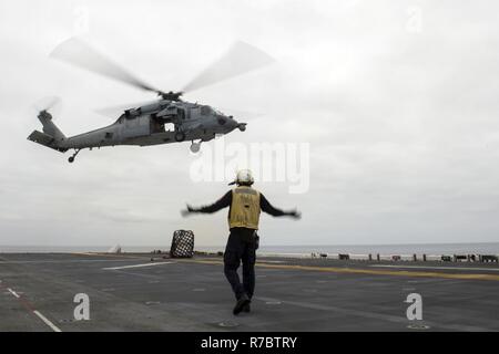 Pazifik (11. Mai 2017) der Luftfahrt Bootsmann Mate (Handling) 3. Klasse Alex Williams, ein Houston Eingeborener, der Abteilung der Amphibisches Schiff USS America zugeordnet (LHA 6), leitet eine MH-60S Seahawk während einer vertikalen Nachschub an den 'Platzhalter' der Heli Attack Squadron 23 zugeordnet. Mehr als 1.800 Segler und 2.600 Marines, die Amerika Amphibious Ready Group (ARG) und dem 15. MEU derzeit eine zusammengesetzte Einheit Übung (COMPTUEX) vor der Küste von Südkalifornien in Vorbereitung auf die Bereitstellung des ARG später dieses Jahr. Amerika ARG Stockfoto