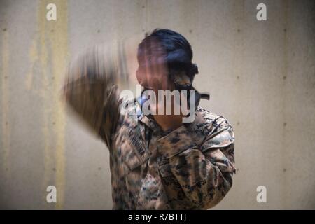 Us Marine Sgt. Brent Serquina bis 1 Platoon, Bravo Company, 9. Unterstützung der Techniker Bataillon, 3D Marine Logistik Gruppe zugewiesen wurde, zieht sich seine Gasmaske für eine militärische Operation urbanem Gelände Bohren auf Camp Hansen, Okinawa, Japan, 11. Mai 2017 vorzubereiten. Diese Schulung wurde durchgeführt, taktische Kenntnisse der Marines in einer Bekämpfung der Umgebung zu erhöhen. Stockfoto