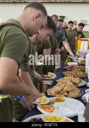 US-Marines mit Bravo Company Headquarters Support Battalion, Marine Corps Installation Pacific (MCIPAC)-Marine Corps Base Camp Butler Essen von Marine Corps Community Services erhalten, nachdem ein Denkmal 5K auf Camp Foster, Okinawa, Japan, 12. Mai 2017 laufen. Der Lauf wurde in Erinnerung an CPL. Sarah Medina, Fotograf und Lance Cpl. Jacob Hug, Bekämpfung Videofilmer mit MCIPAC bekämpfen Kamera; Capt Dustin R. Lukaswicz UH-1Y Venom Piloten und Luftfahrt-Sicherheitsbeauftragter, Captain Christopher L. Norgren ein UH-1Y Venom Pilot, Sgt. Ward M. Johnson ein UH-1Y Venom Hubschrauber Chef und Sgt. Eric M. Seaman Stockfoto