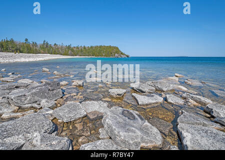 Ruhiges Wasser und Felsen auf einer entfernten Seeufer Stockfoto