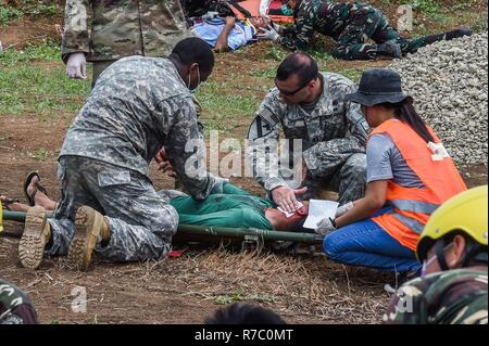 Us-Armee Sgt. 1. Klasse Courtney Lindsay und Kapitän Charles nahe, Pennsylvania National Guard, der Fürsorge für Verwundete Rolle Spieler während eines simulierten Mass Casualty Szenario zur Unterstützung der Balikatan 2017 auf der Insel Calayan Mai 16, 2017. Durch die Ausbildung der Philippinischen und US-Militär bauen auf gemeinsame Taktiken, Techniken und Verfahren, Bereitschaft und Reaktion auf Naturkatastrophen zu verbessern. Balikatan ist eine jährliche US-Philippinischen bilaterale militärische Übung konzentriert sich auf eine Vielzahl von Missionen, einschließlich humanitärer Hilfe und Katastrophenhilfe, Terrorismusbekämpfung und anderen Mähdrescher Stockfoto