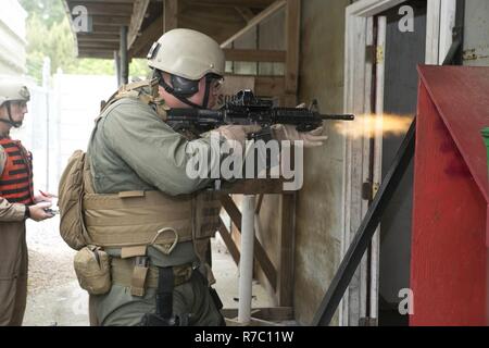 Dozenten mit Ausbildung Co., US Marine Corps Security Force Regiment zu prüfen, um ihre Studenten mit taktischen Bewertungen L-förmige Zimmer während der Close Quarters Battle 2-17 Kurs klar 10. Mai an Bord Naval Support Activity Nordwesten Anhang, Chesapeake, Virginia. Studenten auf ihre Fähigkeit, ein Zimmer zu löschen geprüft wurden und wie schnell Sie in der Lage sind, mögliche Bedrohungen und die Insassen zu adressieren. Stockfoto