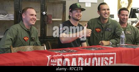NASCAR Fahrer Kurt Busch wirft mit, von Links nach Rechts, Capts. Benjamin Donaldson, Wilfred Navarro, und Daniel Langford bei seinem Besuch in Marine Corps Air Station Cherry Point, N.C., 16. Mai 2017. Busch met mit Service Mitglieder und ihre Familien am Roadhouse Bar und Grill, wo Er unterzeichnete Erinnerungsstücke und Fotos Stockfoto