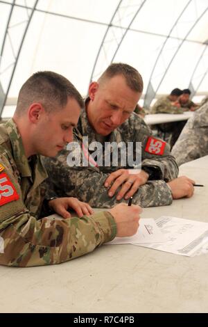 Die Mitglieder von Team 35, Vertreter der Iowa Army National Guard, die schriftliche Prüfung in der US-Armee am besten Sapper Wettbewerb 2017 angehen, statt 25. bis 27. April in Fort Leonard Wood, Mo-Team 35 besteht aus Sgt. 1. klasse James Walze, von Fort Madison, Iowa, ein platoon Sergeant zugeordnet zu Unternehmen A, 224Th Engineer Brigade Bataillon, in Mount Pleasant, Iowa, 1 Leutnant Thomas Bentley, Executive Officer der Firma A. Stockfoto