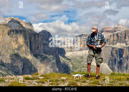 Drone Pilot nimmt eine Drohne in den Dolomiten mit der Marmolada im Hintergrund Stockfoto