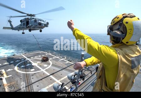 Gewässer südlich von Japan (12. Mai 2017) Elektroniker 3. Klasse Jonathan Hill führt einem MH-60R Sea Hawk Hubschrauber zum "Warlords" von Hubschrauber Maritime Strike Squadron (HSM) 51 während einer vertikalen Auffüllung Training an Bord der Arleigh-Burke-Klasse geführte Anti-raketen-Zerstörer USS McCampbell (DDG85). Das Schiff ist auf Patrouille in den USA 7 Flotte Bereich für Maßnahmen zur Erhöhung der Sicherheit und Stabilität in der Indo-Asia-Pazifik-Region. Stockfoto