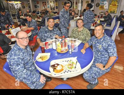 (POLARIS, Guam) Mai 16, 2017 - Von rechts nach links, hinten Adm. Stephen Williamson, Direktor der Fleet Maintenance, US Pacific Fleet, und Kapitän Douglas A. Bradley, submarine Tender USS Emory S. Land (39) kommandierenden Offizier, Essen mit Yeoman 1. Klasse David Lomeli und Machinist Mate Feuerwehrmann Kameron Finchum bei Diner 39, das Chaos deck gewonnen, während einer Tour an Bord, Mai 16. Williamson tourte das Schiff und andere Reparaturarbeiten Einrichtungen in Guam aktuelle Wartungs- und Fähigkeiten zu beurteilen. Land und USS Frank Kabel (wie 40), der US-Navy ist nur zwei U-Angebote, sind beide homepo Stockfoto