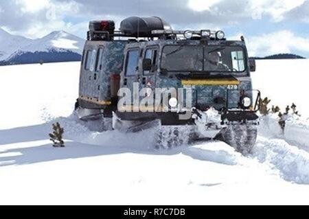 M973A1 die kleine Einheit Begleitfahrzeug, aka SUSV, gekleidet in Notleuchten und digital Camouflage, krallen sich seinen Weg durch den Schnee bei Taylor Park Reservoir in der Nähe von Gunnison, Colo., 15. März 2010. Die SUSV, das in der Lage ist, das Verfahren fast jedes Gelände ist, ist die primäre Fahrzeug von Schnee Response Team des Colorado Army National Guard eingesetzt. Diese relativ unbekannte Asset kann von der SRT verwendet werden, staatlichen und lokalen Rettungskräfte bei fast jeder Art von Notfall, Notruf oder der Suche und Rettung zu unterstützen. Stockfoto