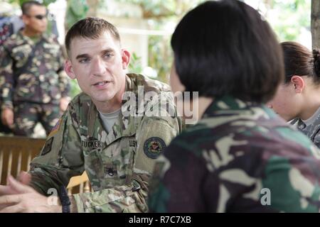 U.S. Army Staff Sgt. Keeton Tucker, Links, beschreibt Familie überleben und Evakuierungspläne für potenzielle Naturkatastrophen mit Einheimischen von Baranguy Popolon, Neuenkirchen, Stadt, 12. Mai 2017 als Teil der Balikatan 2017. Balikatan ist eine jährliche US-Philippinischen bilaterale militärische Übung auf einer Vielzahl von Missionen, einschließlich humanitärer Hilfe und Katastrophenhilfe, Terrorismusbekämpfung und andere kombinierte militärische Operationen ausgerichtet. Stockfoto