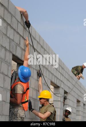 US Army Reserve und Belize Defence Force Ingenieure heben und heben eine Bewehrung-Tie, die die letzte Zeile der Cinderblock in der St. Matthäus staatliche Schule Klassenzimmer Zusatz 1. Mai 2017, ein Teil des Bereichs Beyond the Horizon 2017 verstärken wird. 372nd Ingenieure aus Pewaukee, Wisconsin sind die dritte Rotation der Soldaten, die zur Vervollständigung dieser Baustelle arbeiten. BTH ist eine US Southern Command gesponsert, Armee Süd-geführten Übung zur Bereitstellung humanitärer und engineering-Dienstleistungen für Gemeinden in Not US-Unterstützung für Belize zu bekunden. Stockfoto