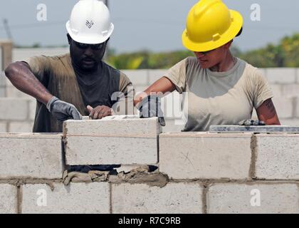 Sgt. Fatima Nevels, eine Reserve signal Support-Spezialisten mit dem 372. Ingenieur Betrieb Pewaukee, Wisonsin, legt die letzten Cinderblock mit Belize Defence Force Light Ingenieur, Sgt. Gilbert Swaso, während jenseits der Horizont 2017 bei St. Matthews, Belize, 1.Mai. BTH ist eine US Southern Command gesponsert, Armee Süd-geführten Übung zur Bereitstellung humanitärer und engineering-Dienstleistungen für Gemeinden in Not US-Unterstützung für Belize zu bekunden. Stockfoto