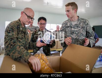 U.S. Navy Commander Jon Conroe präsentiert Katastrophe Hilfsgüter philippinischen Armee Oberstleutnant Joel Albarda und US Army Spc. Alec Horner während einer Community Relations-Veranstaltung zur Unterstützung Balikatan 2017 bei Camp Dela Cruz in Upi, Gamu, 12. Mai 2017. Conroe ist Kaplan mit US Marine Corps Forces Pacific und Albarda ist ein Kaplan mit den Streitkräften der Philippinen. Community-Events, die philippinische ermöglichen und USA Mitglieder zu lokale philippinische Gemeinschaften auf mögliche Naturkatastrophen vorbereiten service. Balikatan ist eine jährliche US-Philippine bilaterale militärische Übung konzentrierte sich auf eine Vielzahl von missio Stockfoto