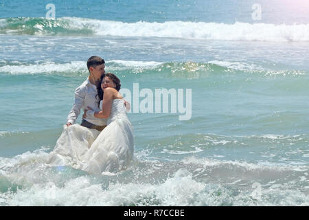 Glückliche Brautpaar Umarmung und Lachen in den Gewässern des Indischen Ozeans. sonnigen Tag der Hochzeit und Flitterwochen in den Tropen auf der Insel Sri Lanka Stockfoto
