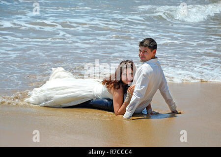 Ein Ehepaar liegt auf dem Sand am Strand des Indischen Ozeans. Hochzeit und Flitterwochen in den Tropen auf der Insel Sri Lanka Stockfoto