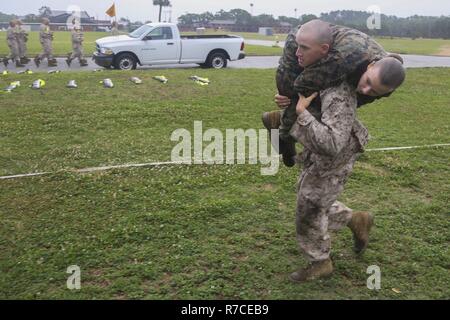 Us Marine Corps Rct. Dylan Marquart, Platoon 2041, Golf Company, 2 Recruit Training Bataillon, trägt Rct. Michaela Burchett, Platoon 4021, Oscar Firma, 4 Recruit Training Bataillon, während einer ersten Combat Fitness Test auf Marine Corps Recruit Depot Parris Island, S.C., 13. Mai 2017. Eine erste CFT wird verwendet, um zu beurteilen, wie die rekruten sind für ihre abschließenden CFT, das ist ein Studium Voraussetzung. Us Marine Corps Stockfoto