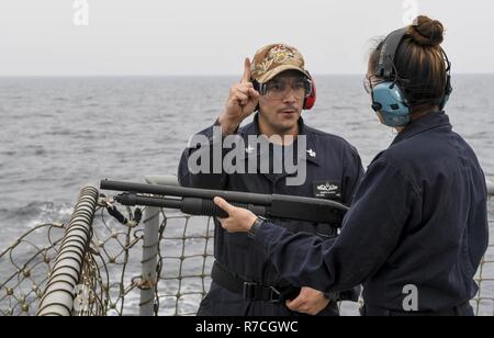 WESTERN PACIFIC (12. Mai 2017) Der Gunner Mate 1. Klasse Joseph Alvarez (links), aus San Diego, gibt der Kurs von Feuer zu Feuer Controlman 2. Klasse Robin Norris, von Wailuku, Hawaii, wie sie bereitet eine Mossberg 500 Schrotflinte während der Einarbeitung live-Fire Schießen an Bord der Arleigh-Burke-Klasse geführte Anti-raketen-Zerstörer USS Wayne E.Meyer (DDG108) Die US-Marine die Indo-Asia Pacific routinemäßig Seit mehr als 70 Jahren die Förderung von Frieden und Sicherheit in der Region patrouillierten hat zu schießen. Stockfoto