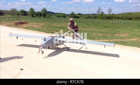 Sgt. Eric Blanton, ein unbemanntes Flugzeug Systeme für Unternehmen D, Feuerwehr 588th Engineer Battalion, 3. gepanzerte Brigade Combat Team, 4 Infanterie Division repairer, sammelt eine RQ-7B Shadow unbemannte Luftfahrzeuge nach der erfolgreichen Landung auf einer übereilten Landebahn auf einem Feldweg bei Grafenwöhr Training Area, Deutschland, 16. Mai 2017. Co.D UAS Platoon beendet seine erste überstürzten Landung, die zeigen, dass Luft Aufklärungssysteme der Brigade in einem Kampf zusammen mit dem Rest der Brigade bewegen kann. Die 3/4 ABCT Züge täglich unter dem U.S. Army Europe Atlantic mission lösen als zu dienen Stockfoto