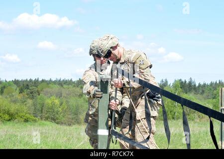 Sgt. Craig Herboth (links) und Sgt. Eric Blanton, beide Unmanned Aircraft Systems Werkstätten mit Unternehmen D, Feuerwehr 588th Engineer Battalion, 3. gepanzerte Brigade Combat Team, 4 Infanterie Division, montieren Sie einen Blickfang gang Net als sekundäre Verriegelung in Vorbereitung für die Landung eines RQ-7B Shadow unbemannte Luftfahrzeuge auf eine übereilte Landebahn auf einem Feldweg bei Grafenwöhr Training Area, Deutschland, 16. Mai 2017 verwendet. Co.D UAS Platoon beendet seine erste überstürzten Landung, die zeigen, dass Luft Aufklärungssysteme der Brigade in einem Kampf zusammen mit dem Rest der Brigade bewegen kann. Die Stockfoto