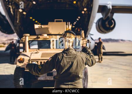 Einen Flieger mit dem 729 . Airlift Squadron, Air Force Reserve Command, führt ein Humvee auf eine C-17 Globemaster III der Air Combat Element Landebahn als Teil einer schnellen Bereitstellung bereit Übung in der Marine Corps Air Ground Combat Center, Twentynine Palms, Calif., Nov. 28, 2018. Der Zweck dieser Übung war 2nd Battalion, 7th Marine Regiment, 1st Marine Division Fähigkeiten anzuzeigen seinen Befehl Vermögen überall auf der Welt in 96 Stunden innerhalb von 24 Stunden im Voraus bereitzustellen. Stockfoto