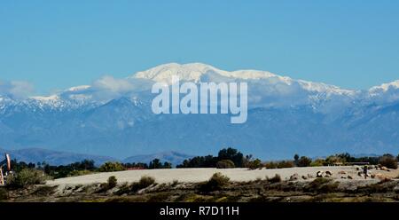 Ein Blick auf die schneebedeckten Mt. Baldy in der Entfernung von der Feuchtgebiete in Huntington Beach, Kalifornien im Dezember getroffen. Stockfoto