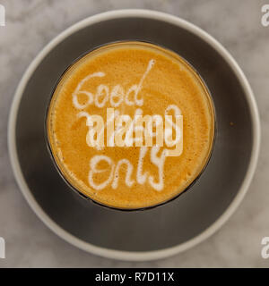 Tasse Kaffee Latte auf eine Tabelle, mit guten Nur Vibes, latte Art und eine Schokolade Cookie auf der Seite. Quadratisches Bild. Stockfoto