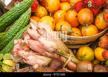 Gelbe Passionsfrucht, Rambutan und Banane Blumen an einem traditionellen Bauernmarkt, Bali, Indonesien. Stockfoto