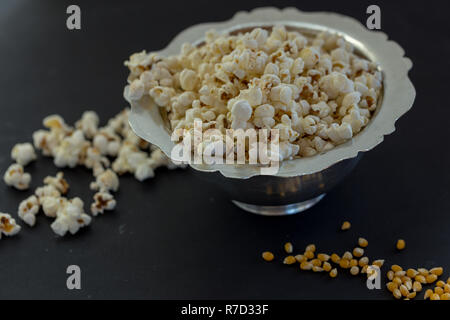 Popcorn Popcorn und Körner in Kupfer Topf auf schwarzen Holztisch