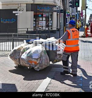 Behälter Säcke & Beutel voller Müll Müll Müll Hand karre in der Einkaufsstraße von Rat-Arbeiter von Seaside Resort Pflaster Behälter gesammelt geschoben Stockfoto