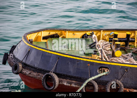 Die bunten Bogen von einem schubschiff in einem griechischen Hafen warten, teilweise mit Blick in ruhiger Frühling. Sauber, Takelage und Autoreifen für Puffer verwendet. Stockfoto