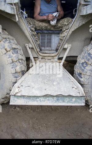 Eine ukrainische Soldaten vom 1. airmobile Bataillon, 79 Air Assault Brigade reinigt Waffen Teile innerhalb seiner Schützenpanzer nach der Teilnahme an einem gunnery Range an der Yavoriv Combat Training Centre, das auf der internationalen Friedenssicherung und Security Center, in der Nähe der Yavoriv, der Ukraine, der am 16. Mai. ( Stockfoto