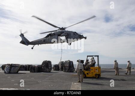 ARABIAN GULF (Nov. 28, 2018) Eine MH-60S Sea Hawk Hubschrauber, der "Blackjacks" der Hubschrauber Meer Combat Squadron (HSC) 21, Ladung das Flight Deck der Wasp-Klasse liefert Amphibisches Schiff USS Essex (LHD2) während eines geplanten Einsatz der Essex Amphibious Ready Group (ARG) und 13th Marine Expeditionary Unit (MEU). Das Essex ARG und 13. MEU sind eine flexible und beständige Navy-Marine Corps Team in die USA 5 Flotte Bereich der Maßnahme zur Unterstützung der Marine im Einsatz für die Stabilität und Sicherheit in der Region zu gewährleisten und verbindet das Mittelmeer und Stockfoto