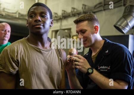 Pazifik (Nov. 28, 2018) Hospital Corpsman 3. Klasse Samuel Keller, rechts, von Baton Rouge, La., verwaltet ein routineimmunisierung Schuss in der Luftfahrt Bootsmann Mate Airman Kvon Fluitt, von Jacksonville, Fla., an Bord der Nimitz-Klasse Flugzeugträger USS John C Stennis (CVN 74). John C Stennis unterwegs ist die Durchführung von Routineaufgaben in der US-Pazifikflotte Bereich der Operationen. Stockfoto